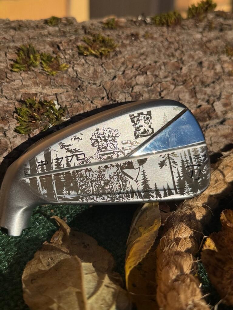 Yksityiskohtainen metsämaisema, sotilas ja leijonavaakuna laserkaiverrettuna TaylorMade-rautaan